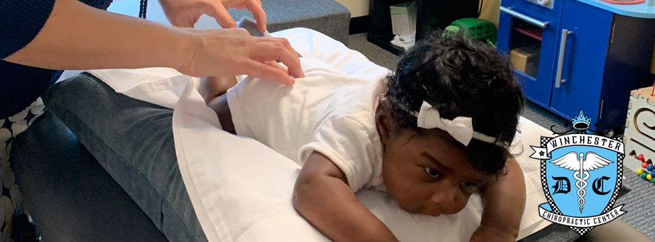 Dr. Henrickson is evaluating a child patient while they are resting on a nice cushion.